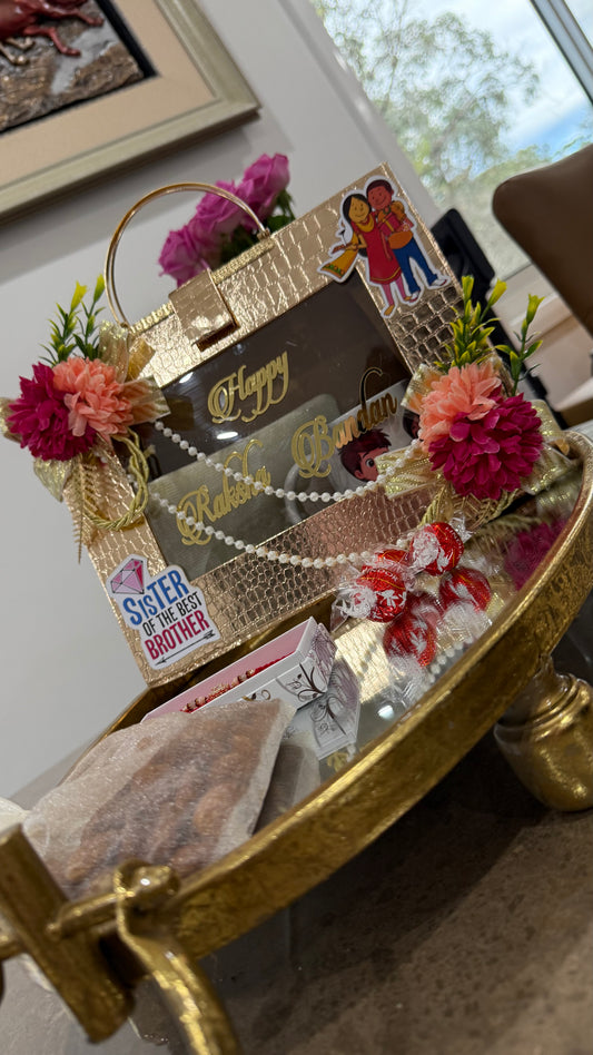 Decorative gift basket with flowers and a card on a table. Bhaiya Bhabhi rakhi lumba set with gift hamper, sweets and diya