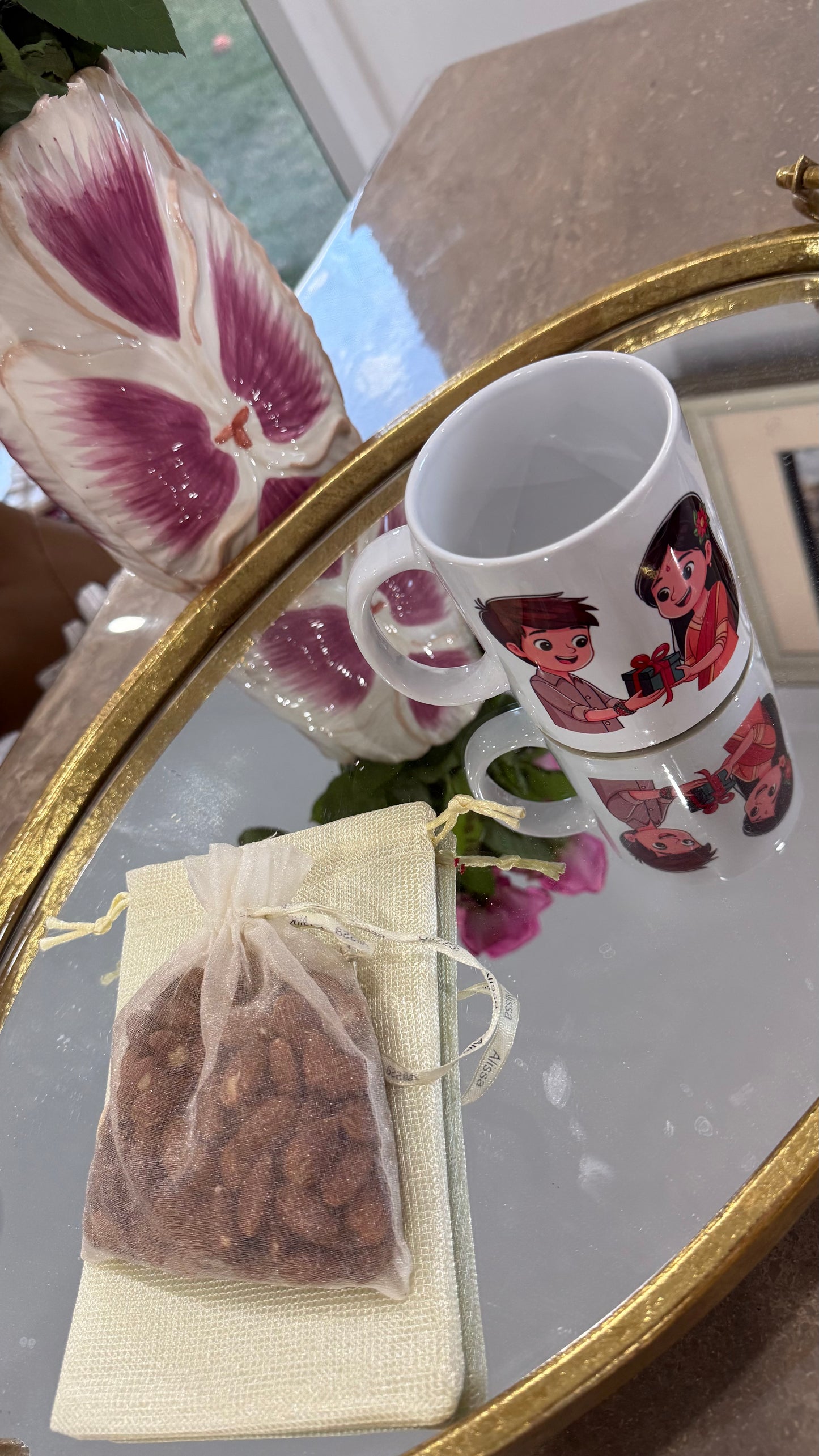 Two mugs with cartoon characters on a reflective surface, Decorative bag for rakhi with dry fruits 