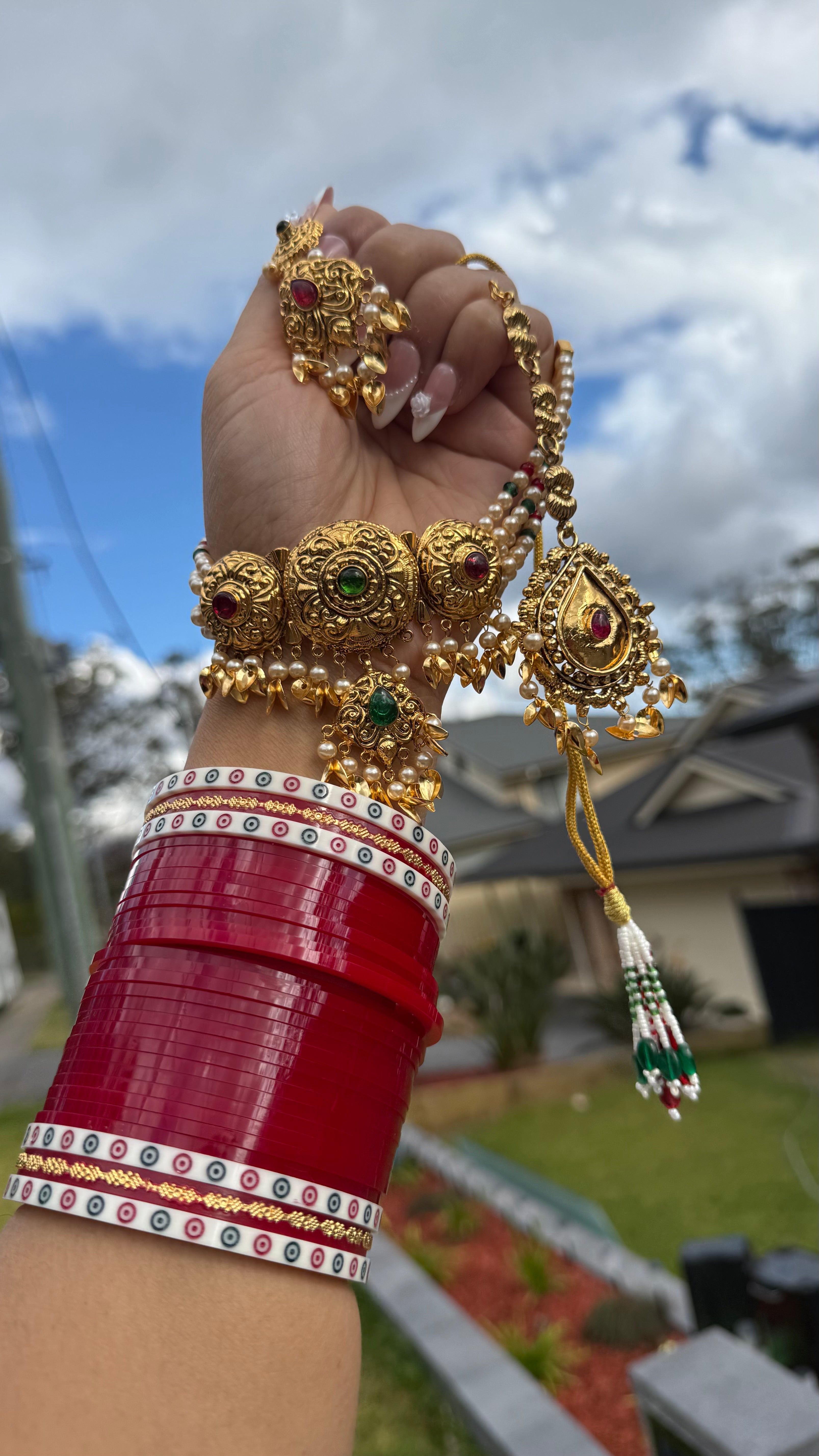 Indian gold plated choker set displayed on mannequin with earrings and tikka